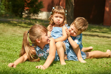 Naklejka na ściany i meble playful children outdoors in the summer on the grass in a backyard