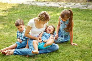 Naklejka na ściany i meble playful family outdoors. mom with children in the summer. Mother and kids