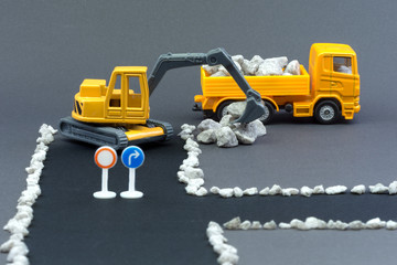 Diorama road construction with yellow construction machinery models. Construction concept....