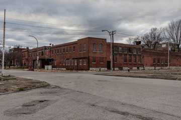 Boarded up and abandoned red brick apartment building in depressed urban area