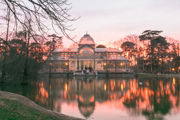 Fototapeta premium The Palacio de Cristal at sunset (Crystal Palace) is a glass and metal structure located in Madrid's Buen Retiro Park