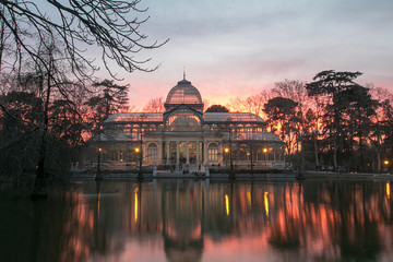 Fototapeta premium The Palacio de Cristal at sunset (Crystal Palace) is a glass and metal structure located in Madrid's Buen Retiro Park