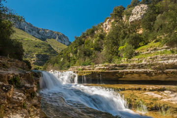 Fototapeta na wymiar Cava Grande del Cassibile Natural Reserve, Siracusa, Sicily, Italy. One of Europe’s biggest canyon, the river Cassabile through majestic mountains and filling emerald water lakes and waterfalls.
