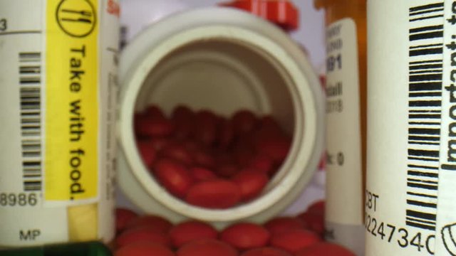 Maco close-up of many pill bottles as the camera travels inside a bottle