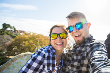 Travel couple happy making selfie portrait with smartphone in Park Guell, Barcelona, Spain.