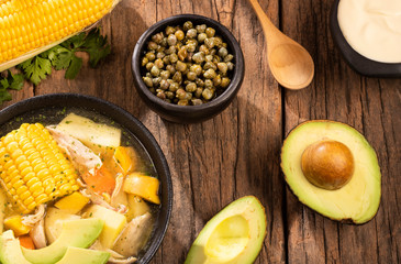 Traditional Colombian ajiaco served on black ceramic dish