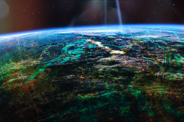 Futuristic internet of things (IoT) links the physical and digital worlds. City lights from outer space. Roads and map relief from motherboard. Elements of this image furnished by NASA.