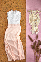 Beautiful unusual outfit presentation for fashion blog, advertising, clothing catalog. Delicate pink dress made of transparent fabric with a white lace bodice. Dream catcher and dry spikelets.
