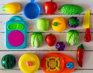 Fruits and vegetables toys on wooden background.