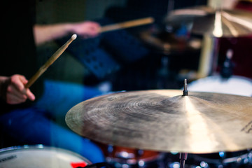 Professional drum set closeup. Man drummer with drumsticks playing drums and cymbals