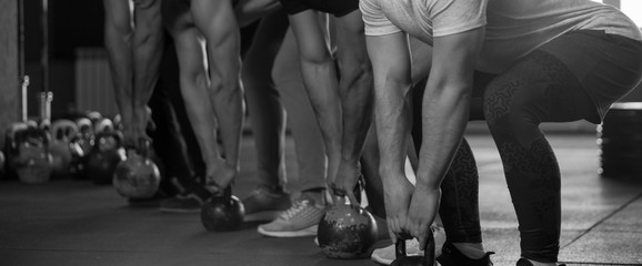 Side View - Fit Young Men Training With Kettlebells in Gym.