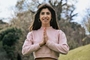 Attractive young woman enjoying her time outside in park with thanks with the expression on face