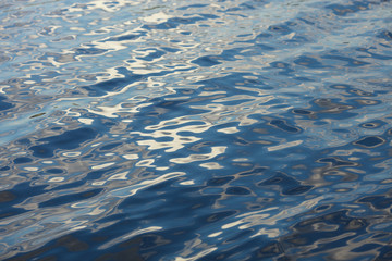 Abstract reflection of the blue sky on the water surface.