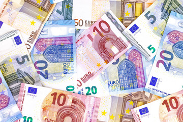 Different kind of euro money banknotes and coins on the table with white background from above view