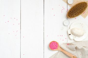 Natural spa, wellness or skin care composition with spoon of pink bath salt, body brush, organic soap, towel and accessories on wooden background, top view, banner mockup. Beauty and health.