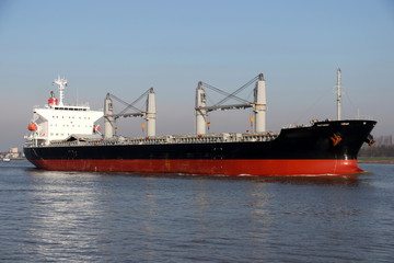 Naklejka premium Massengutfrachter mit Kränen erreicht den Hafen