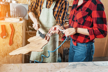 man and woman creatively working in the Studio on a decorative product made of wood