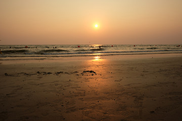 Sunset on the beach of Thailand in Pataeia with silhouettes of boats and people