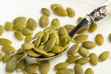 Peeled pumpkin seeds on a dessert spoon