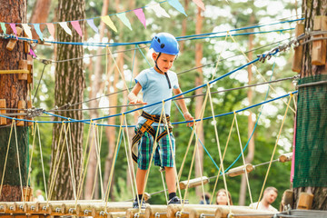 Fototapeta premium Five year boy on rope-way in forest