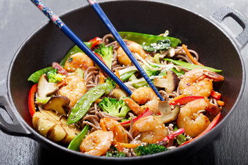 Stir fried noodles with shrimps and vegetables in a wok