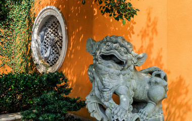 Stone lion sculpture in front of Chinese temple