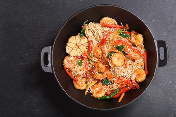 Stir fried noodles with shrimps and vegetables in a wok, top view
