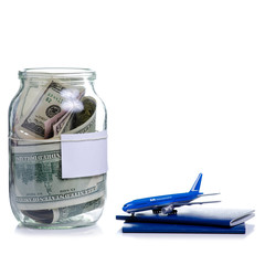 Save money dollars in glass jar for travel on white background isolation
