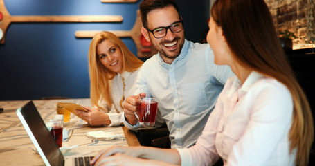 Happy colleagues from work socializing in restaurant