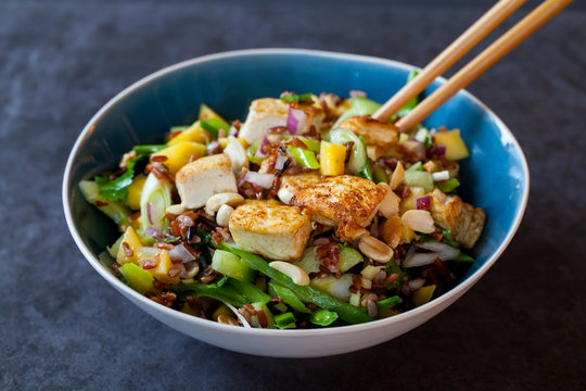Vegan salad with crispy tofu, red and wild rice and mango