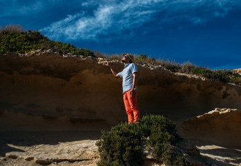 Obraz premium Man in sunglasses and red trousers staying in the hills