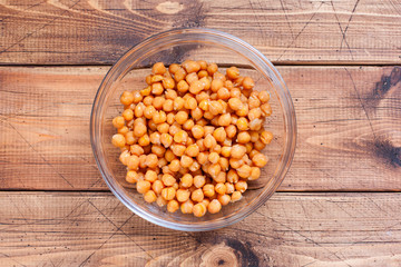 glass of cooked chickpeas on white wooden background
