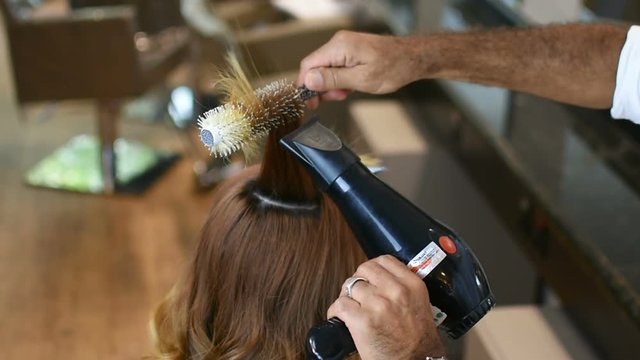 Professional drying of red hair in beauty saloon