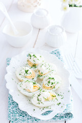 Snack of eggs under mayonnaise on a white plate, selective focus