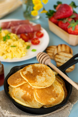 Pancakes with scrambled eggs and ham for breakfast