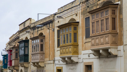 Traditional, wooden balcony and stone facade, typical for architecture of Gozo, Malta