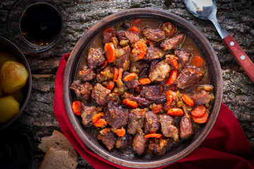 Stewed beef with carrots and onions in pottery, top view, horizontal