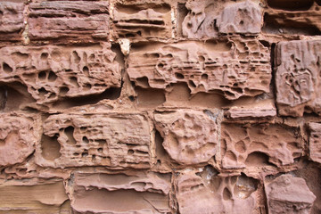Close up image of old textured sandstone brickwork worn by the wind on an English  castle