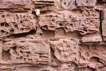 Close up image of old textured sandstone brickwork worn by the wind on an English  castle