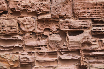 Close up image of old textured sandstone brickwork worn by the wind on an English  castle