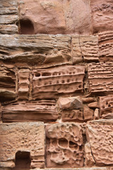 Close up image of old textured sandstone brickwork worn by the wind on an English  castle