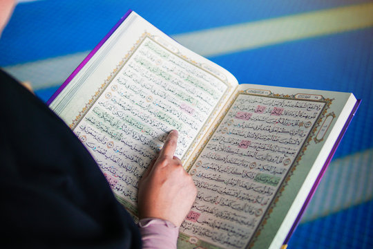 Close up view of muslim woman reading the holy Al Quran inside a mosque