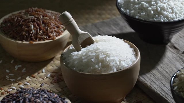 Organic brown rice and asian black riceberry with jasmine white rice in bowl on wooden desk, uncooked products by organic natural food concept