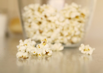 Popcorn on a table and in a glass bowl, light colors.