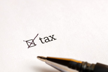 Checked checkbox with word tax and dollars at background. questionnaire concept.