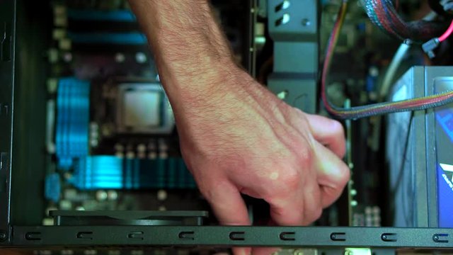 Close-up of male hand uninstalling videocard in PC. Personal computer repair