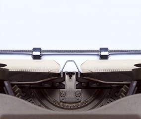 Closeup of a vintage typewriter with blank paper - horizontal image with copy space. 