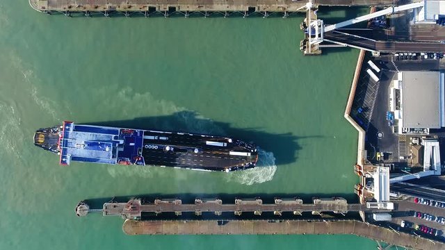 Aerial top down view of ferry docking at port these are merchant vessels used to carry passengers vehicles and cargo and form a part of public transport systems of many waterside cities and islands 4k