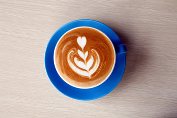 Coffee Latte blue yellow cup on wooden table daylight copy space