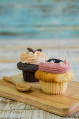 Tasty cupcake on wooden table on vintage background